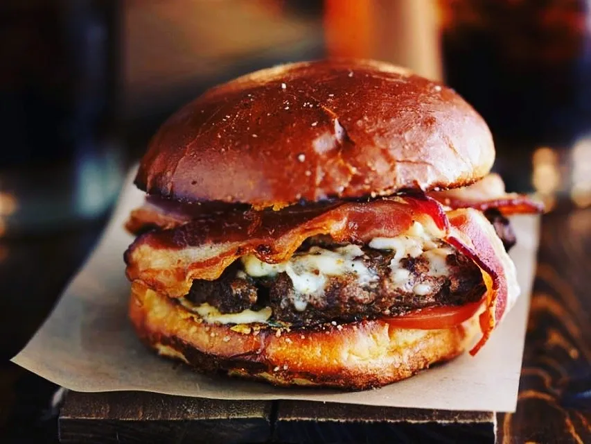 Burger stacked with bacon and cheese